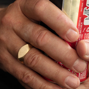 Close-up of model wearing JB ring on right hand while holding can of beer